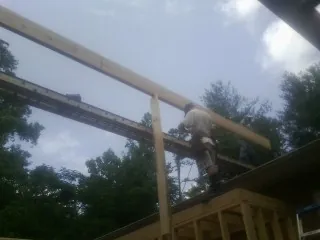 Carpenter setting a ridge beam over a new addition frame — Ice Dam Removal by Roofing Brothers in Elizabeth