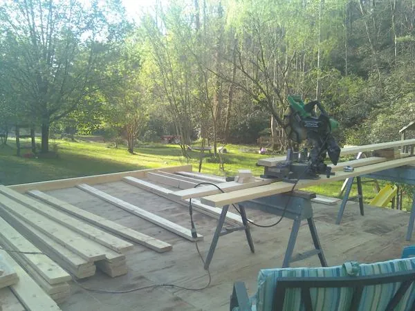 Miter saw and framing lumber on a deck under construction in Elizabeth
